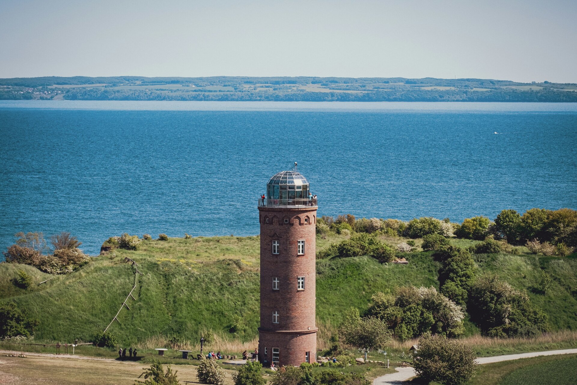 Fotospot Kap Arkona: a lighthouse on a hill overlooking a large body of water